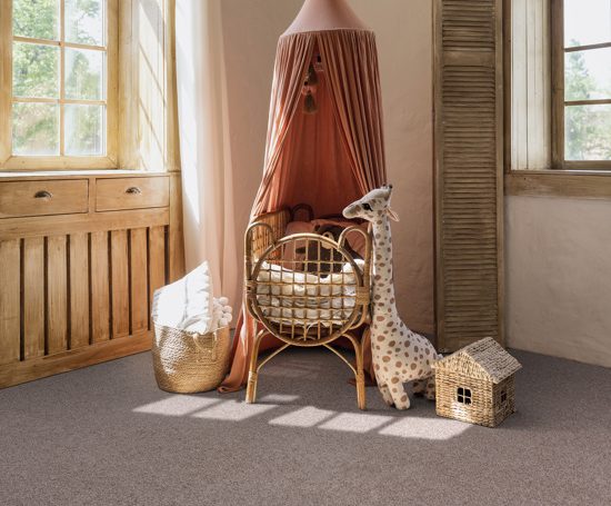 Wickered cradle bed with baldachin in corner of newborn room